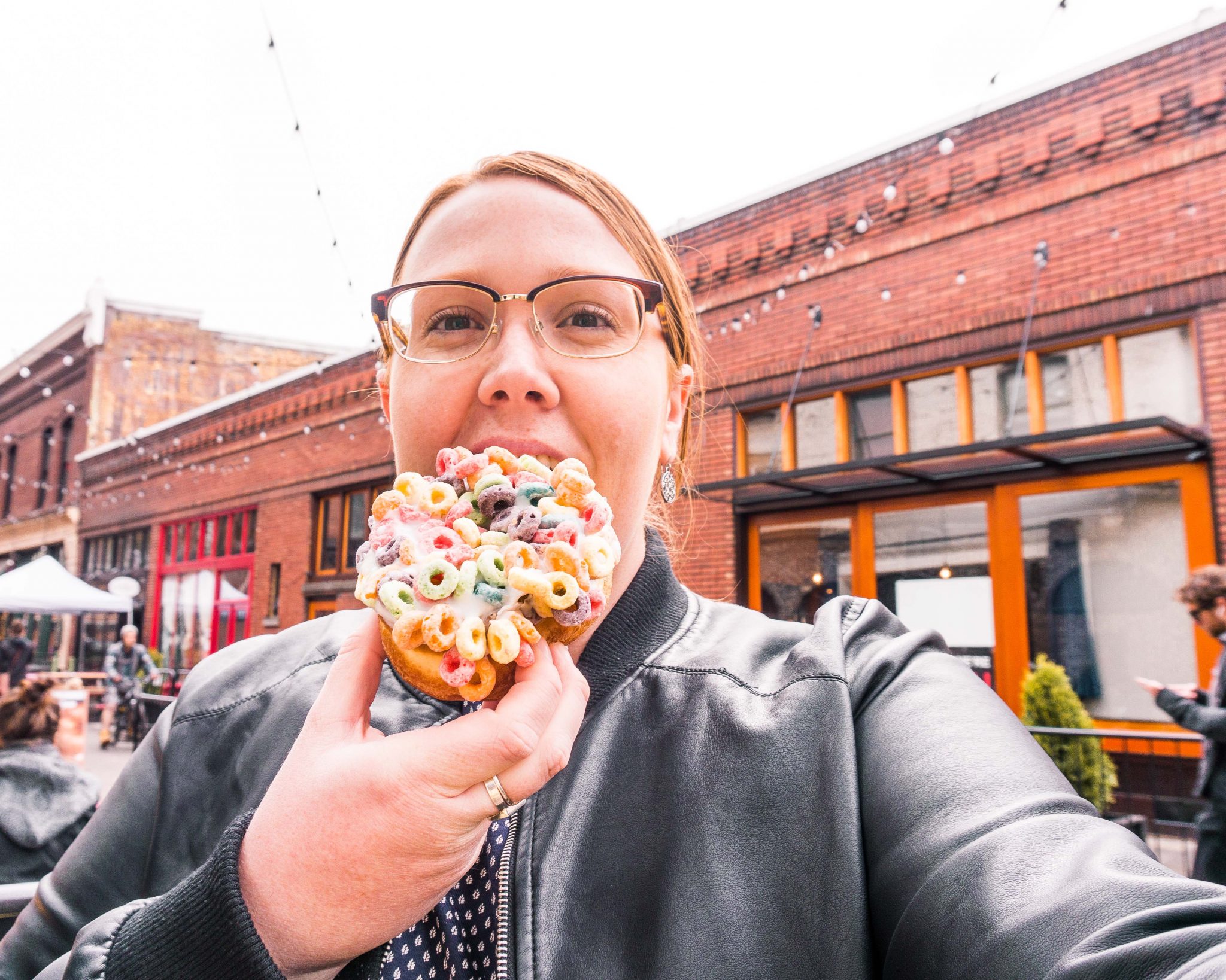 Eating a Froot Loop-covered doughnut from Voodoo Doughnuts in Portland, Oregon