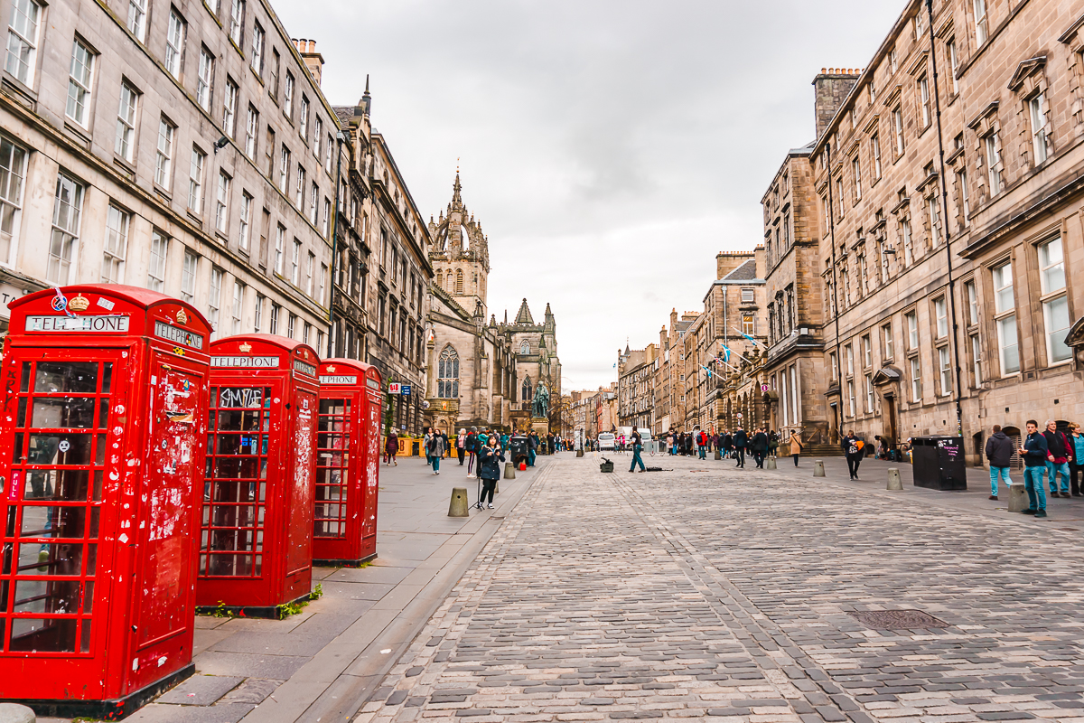 Red phone boxes and quiet cobblestone street in Edinburgh's Old Town