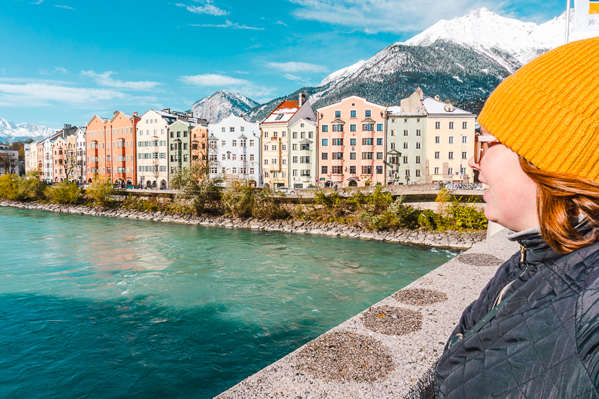 Side profile, looking over aqua river to colourful buildings in Innsbruck, Austria.