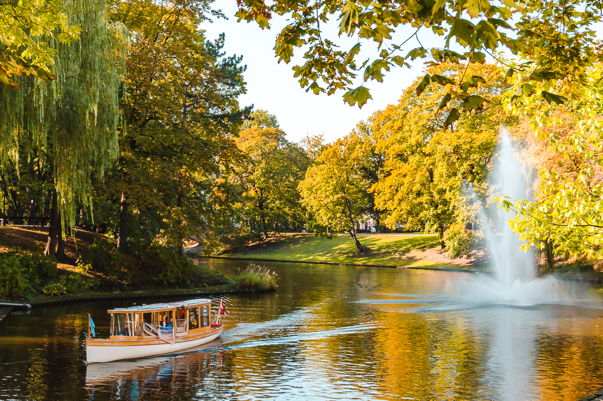 Boat and fountain on river flowing through Bastejkalns Park in Riga, Latvia.